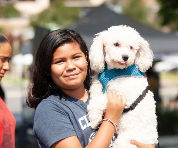 a girl holding up her dog