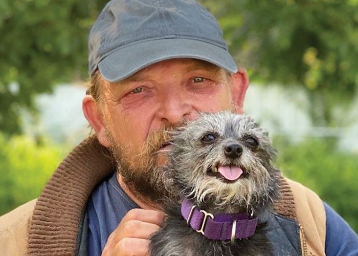 a man holding up his small dog